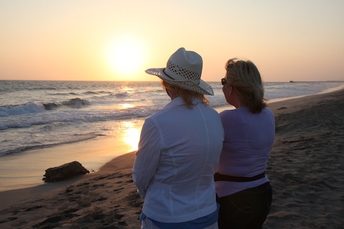 two women at beach at sunset