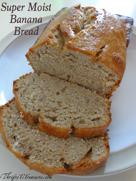 Loaf of banana bread on a plate with two slices cut