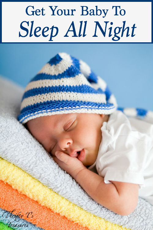 infant sleeping on a stack of colorful towels