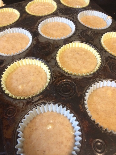 muffin tin with cupcake liners filled with honey banana cupcake mixture