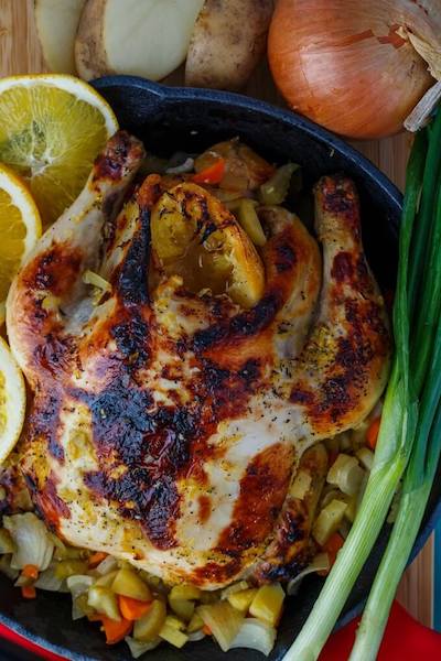 whole chicken surrounded by vegetables