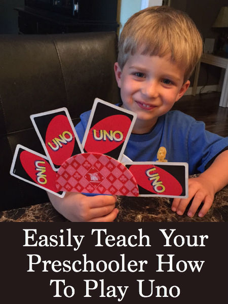 little boy holding uno cards