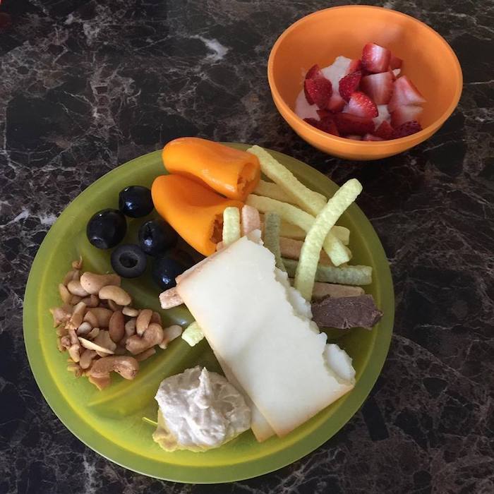 plate of food including cheese, hummus, veggie straws